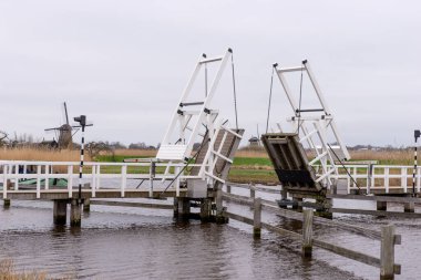 Kinderdijk 'te bir kanalın karşısındaki tahta köprü. Hollanda