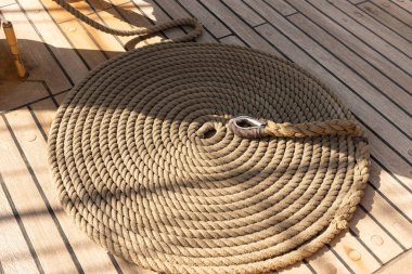 Yelkenli geminin ahşap güvertesinde yuvarlanmış ip.