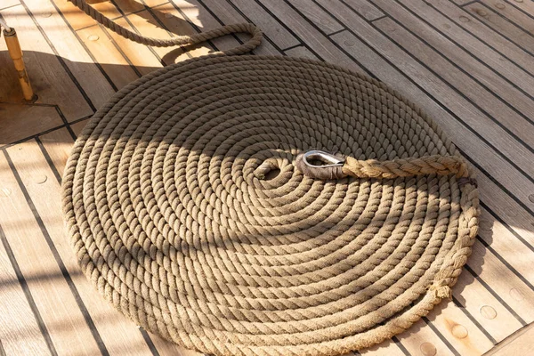 Yelkenli geminin ahşap güvertesinde yuvarlanmış ip.