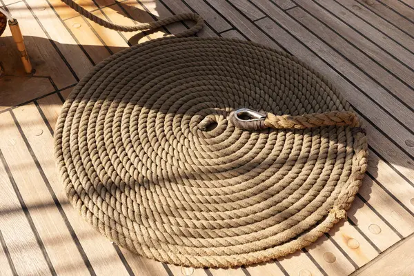 Yelkenli geminin ahşap güvertesinde yuvarlanmış ip.