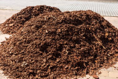 Garaj yolunda ağaç kabuğu yığını var.