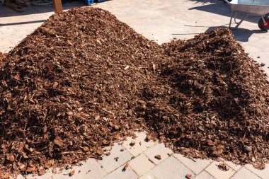 Garaj yolunda ağaç kabuğu yığını var.