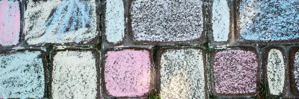 Panoramik görüntü. Renkli beton kaldırım taşları. Çocuklar yeri renkli tebeşirlerle boyadılar.