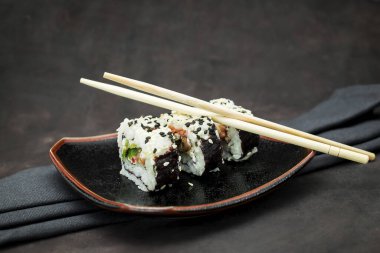 Karanlık arka planda lezzetli bir suşi seti.