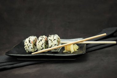 Karanlık arka planda lezzetli bir suşi seti.