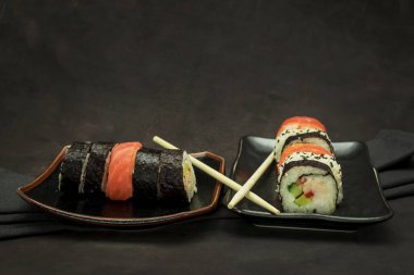 Karanlık arka planda lezzetli bir suşi seti.