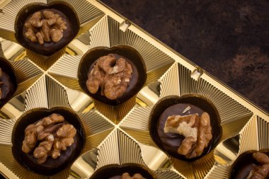 Close up of homemade with dark chocolate pralines filled with walnut 