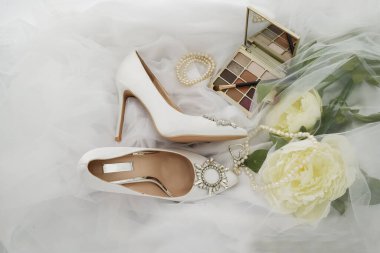 photo of Cosmetics on bright background and wedding shoes