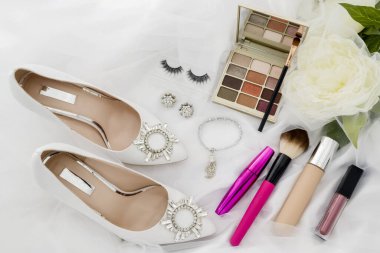 photo of Cosmetics on bright background and wedding shoes