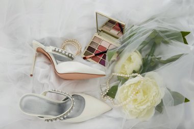 photo of Cosmetics on bright background and wedding shoes