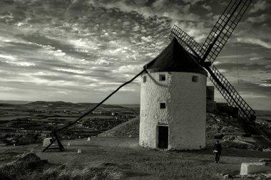 Black ahd white view of a windmill at sunset in Consuegra, a town in the province of Toledo, Spain.