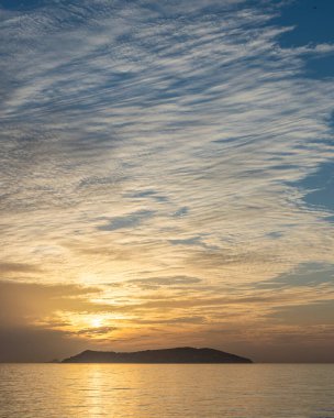 Gün batımında gökyüzünü çizgilerle kaplayan bulutların görüntüsü
