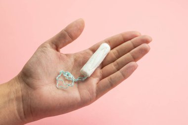 Hand holding a tampon, female menstruation, vaginal bleeding, feminine hygiene