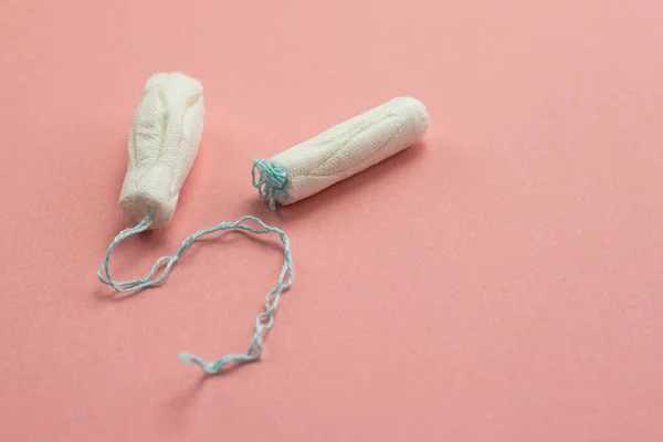 Tampons lying on a pink background, female menstruation