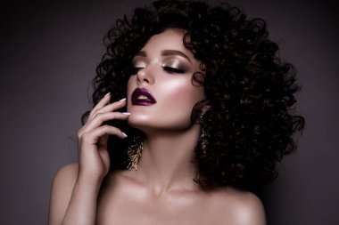 Brunette girl with long and shiny curly hair . Beautiful model woman with wavy hairstyle . High quality photo