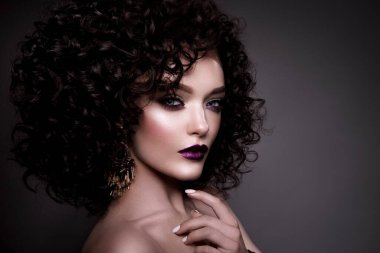 Brunette girl with long and shiny curly hair . Beautiful model woman with wavy hairstyle . High quality photo