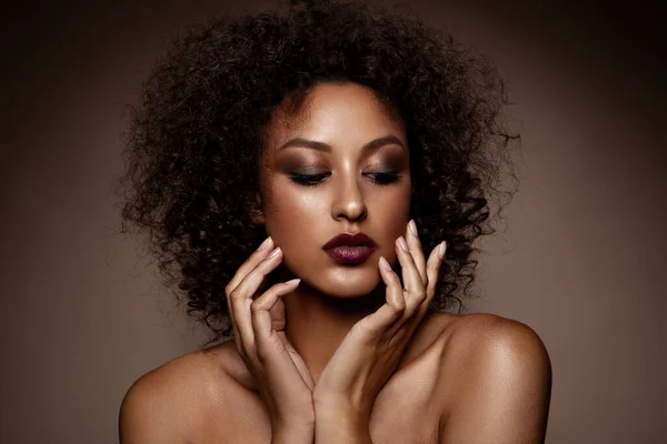 Fashion studio portrait of beautiful african american woman with perfect smooth glowing mulatto skin, smoky eyes make up