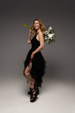 Güzel genç bir kadın elinde bir zambak çiçeği tutuyor. Gençlik ve sağlık kavramı. Yüksek kalite fotoğraf