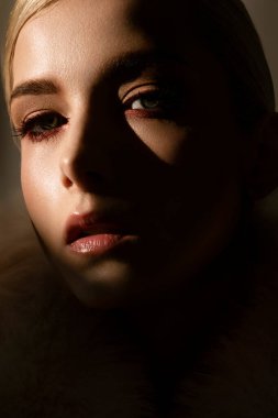 Bu, onun görünüşünü güzelleştiren lüks bir kürk mantoyla süslenmiş güzel bir kadının yakın çekim görüntüsü.