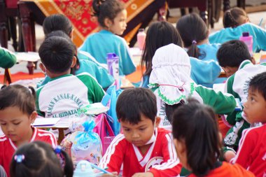 Kindergarten students are drawing together