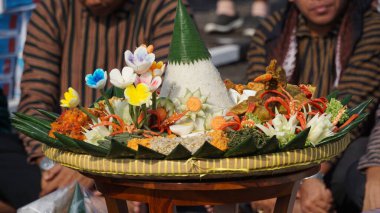 Nasi tumpeng (koni pilavı), urap-urap (Endonezya salatası), kızarmış tavuk ve erişte ile servis edilir. Nasi Tumpeng genellikle doğum günü partilerinde ya da şükran günlerinde servis edilir.
