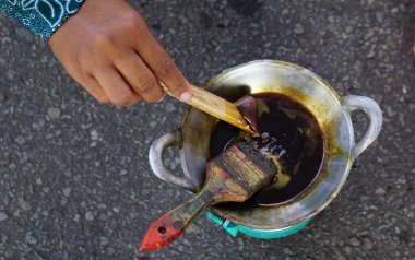 Balmumu (Endonezyalılar buna malam der) tavada erir. Bu balmumu batik kumaş yapımında kullanılır.