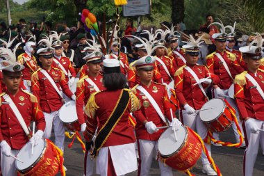 Taruna Brawijaya Lisesi, seçim karnavalı (Kirab Pemilu) partisi için davul çalıyor.