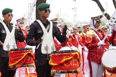 Taruna Brawijaya Lisesi, seçim karnavalı (Kirab Pemilu) partisi için davul çalıyor.