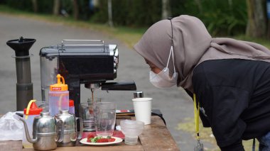 Barista bir müşteriye kahve servisi yapıyor.