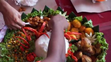 Şefin servis ettiği Nasi Tumpeng (koni pilavı), urap-urap (Endonezya salatası), kızarmış tavuk ve erişte ile servis edilir. Nasi Tumpeng genellikle doğum günü partilerinde ya da Şükran Günü 'nde servis edilir.