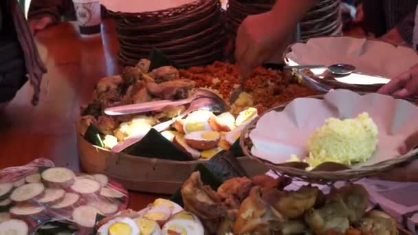 インドネシア風のサラダやフライドチキン 麺などがついている ナシタンポンは通常誕生日パーティーや感謝祭で提供されています — ストック動画