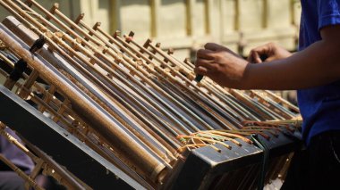 Bir adam angklung oynuyor. Bu, Sundan halkının geliştirdiği çok tonlu bir müzik aleti. Angklung bambudan yapılır.