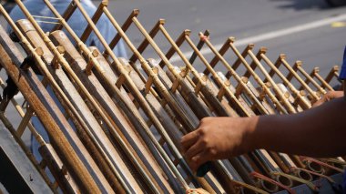 Bir adam angklung oynuyor. Bu, Sundan halkının geliştirdiği çok tonlu bir müzik aleti. Angklung bambudan yapılır.