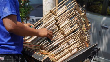 Bir adam angklung oynuyor. Bu, Sundan halkının geliştirdiği çok tonlu bir müzik aleti. Angklung bambudan yapılır.