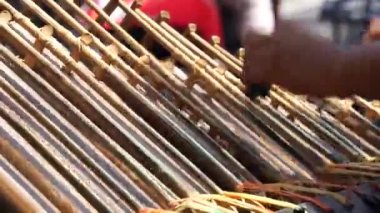 Bir adam angklung oynuyor. Bu, Sundan halkının geliştirdiği çok tonlu bir müzik aleti. Angklung bambudan yapılır.