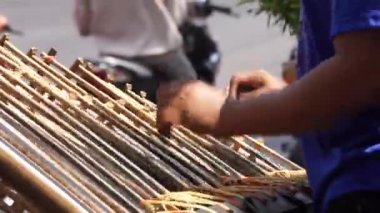 Bir adam angklung oynuyor. Bu, Sundan halkının geliştirdiği çok tonlu bir müzik aleti. Angklung bambudan yapılır.
