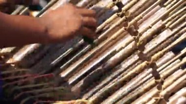 Bir adam angklung oynuyor. Bu, Sundan halkının geliştirdiği çok tonlu bir müzik aleti. Angklung bambudan yapılır.