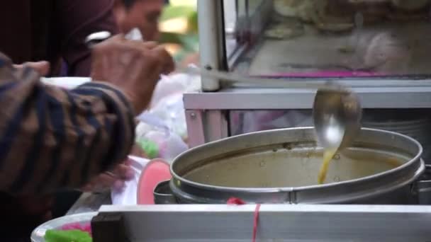 伝統的な市場でのバイヤーのためのドーセットセラビ ココナッツミルクとパームシュガーで食べられる ジャワの伝統的な米粉のストランドです — ストック動画