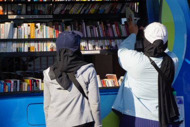 İnsanlar kütüphane vagonunda kitap okuyor.