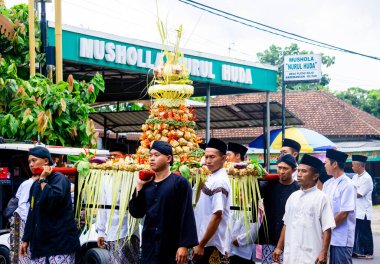 Kirab ketupat 'ta yemek paylaşıyoruz. Kirab ketupat, ücretsiz yiyecek dağıtarak Kurban Bayramı 'nın kutlamasıdır.
