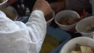 Kirab ketupat 'ta yemek paylaşıyoruz. Kirab ketupat, ücretsiz yiyecek dağıtarak Kurban Bayramı 'nın kutlamasıdır.
