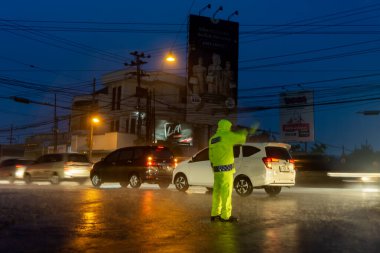 Polis gece yağmur yağdığında araç trafiğini düzenliyor