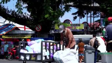 Eski püskü giysiler içinde yaşlı insanlar satmak için plastik şişe arıyorlar.