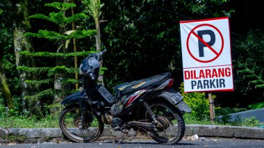 Siyah eski motosiklet tabelasının önünde. Park yasak.