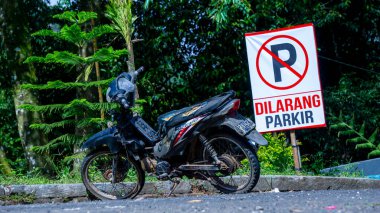 Siyah eski motosiklet tabelasının önünde. Park yasak.