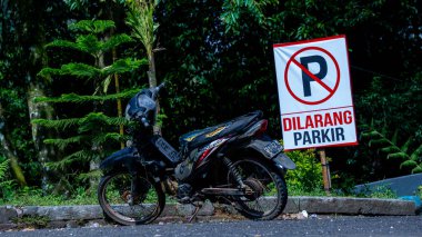 Siyah eski motosiklet tabelasının önünde. Park yasak.