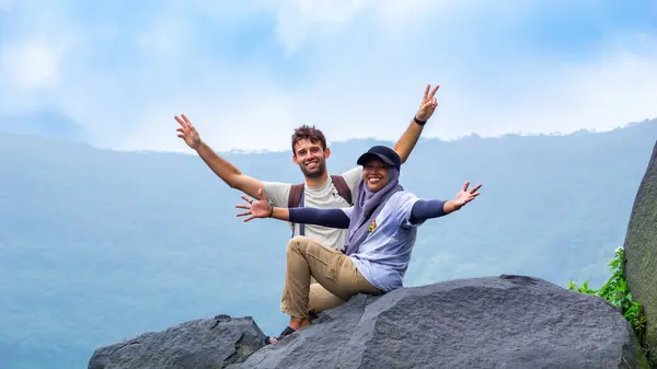 stock image Foreign tourists on a large rock with a view of Mount Kelud