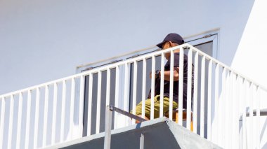 Beyaz binalı balkonda insanlar var.