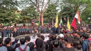 Öğrenciler, hanedan siyasetini ve seçim yasasındaki değişiklikleri reddettiklerini gösteren işaretler taşıyarak gösteri yapıyorlar..