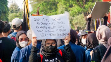 Öğrenciler, hanedan siyasetini ve seçim yasasındaki değişiklikleri reddettiklerini gösteren işaretler taşıyarak gösteri yapıyorlar..